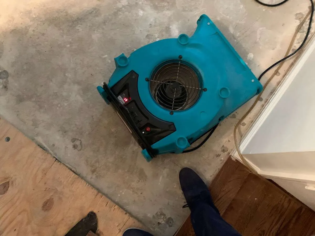 Air mover drying subfloor during Commercial Water Damage Restoration in McComb